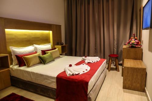a hotel room with a large bed with a red blanket at LE VOYAGEUR MARRAKECH in Marrakesh