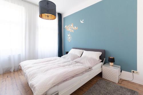 a bedroom with a bed with a blue wall at Wohnen wie zuhause - zu Gast in Erfurt in Erfurt
