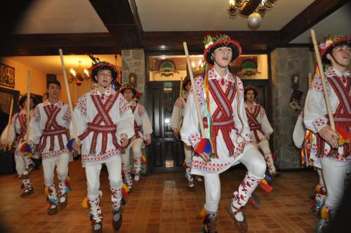 a group of people in folk costumes walking down a hallway at Casa Bradet in Întorsura Buzăului
