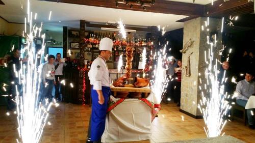 a chef standing next to a table with food on it at Casa Bradet in Întorsura Buzăului