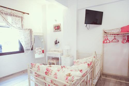 a white room with a crib and a tv at Studio Lefaki in Rethymno Town