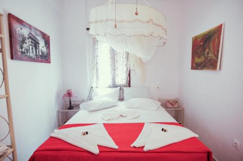 a bedroom with a red and white bed with a window at Studio Lefaki in Rethymno Town