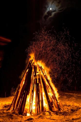 a fire in the sand at night with a tree at Casa Bradet in Întorsura Buzăului