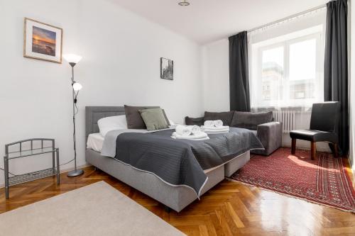 een slaapkamer met een bed en een stoel bij City Centre Apartment in Warschau
