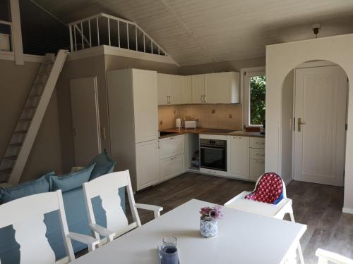 a kitchen with a table and chairs and a staircase at Wohlfühloase Villa Sunshine an weißem Sandstrand in Dahme