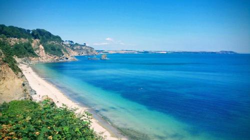 an aerial view of a beach with blue water at So Tranquil in Charlestown