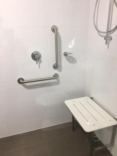 a white shower with a bench in a bathroom at Robe Marina Accommodation in Robe