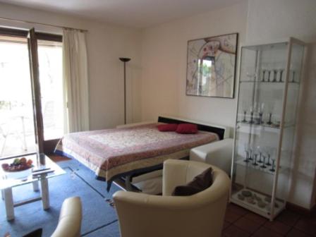 ein Schlafzimmer mit einem Bett, einer Couch und einem Sessel in der Unterkunft Residenz degli Angioli in Ascona
