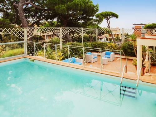 a swimming pool with chairs and a fence around it at Hotel Mignon in Forte dei Marmi