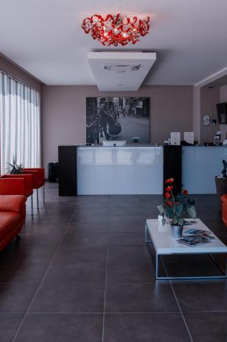a lobby with red furniture and a red chandelier at Hotel I Crespi in Grosseto