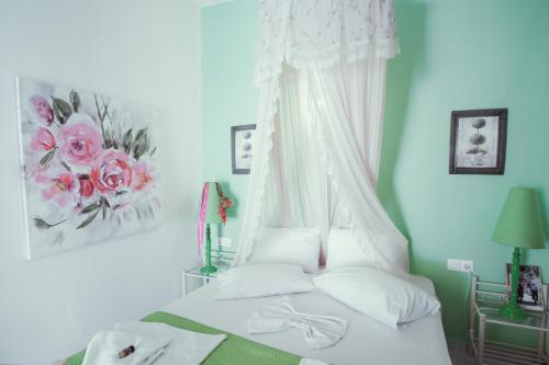 a bedroom with a white bed with a canopy at Studio Lefaki in Rethymno Town
