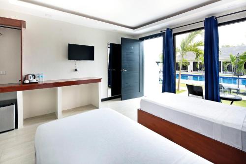 a hotel room with two beds and a view of a pool at OHANA, Panglao Resort. in Panglao