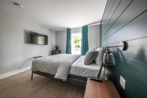 una camera da letto con un letto grande e una finestra di Square Victoria Maison Hôtelière a East Angus