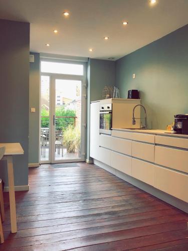 Il comprend une cuisine dotée de parquet et d'une grande fenêtre. dans l'établissement Nuit en Ville Lille La Madeleine, à La Madeleine