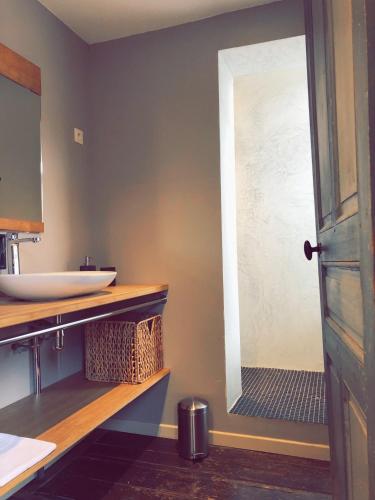 La salle de bains est pourvue d'un lavabo et d'une porte de douche en verre. dans l'établissement Nuit en Ville Lille La Madeleine, à La Madeleine