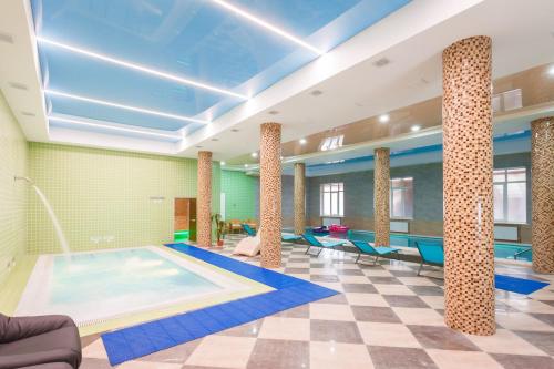 uma piscina num quarto com piso de xadrez em Triumph Hotel em Krasnodar