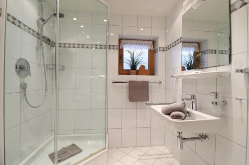 y baño blanco con lavabo y ducha. en Landhaus Am Schelmenhag 13a en Oberstdorf