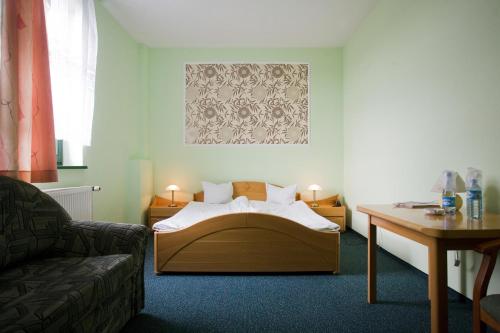1 dormitorio con cama, mesa y sofá en Hotel Mały Młyn, en Stargard