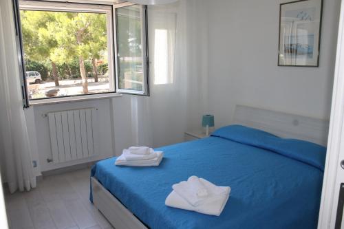 a bedroom with a blue bed with towels on it at A casa di Marta in Bari