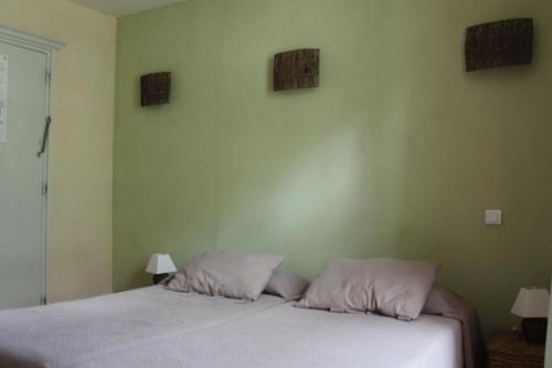 a bedroom with a bed with two pillows on it at Hôtel de Valdeblore in Valdeblore