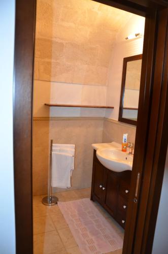 ein Bad mit einem Waschbecken und einem Spiegel in der Unterkunft B&B Carpignano affittacamere in Palagianello