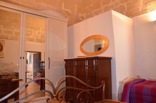 Zimmer mit einem Stuhl und einem Spiegel an der Wand in der Unterkunft B&B Carpignano affittacamere in Palagianello