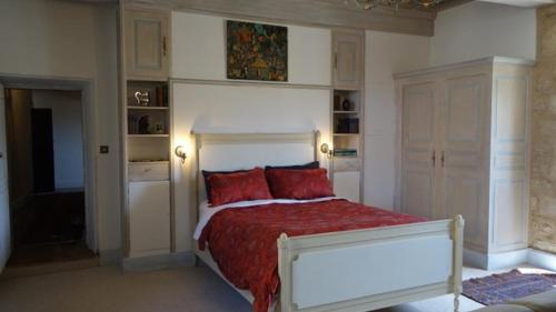 een slaapkamer met een groot bed met rode kussens bij Chateau de Balsac in Balsac