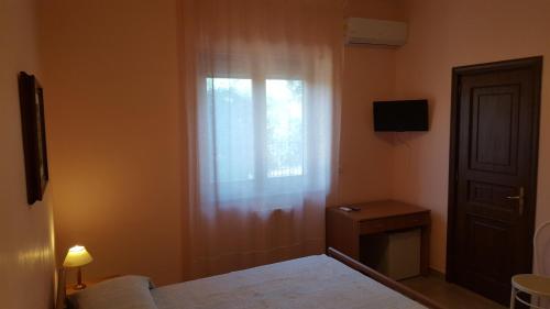 een slaapkamer met een raam, een bed en een tafel bij Villa Erry in Trani