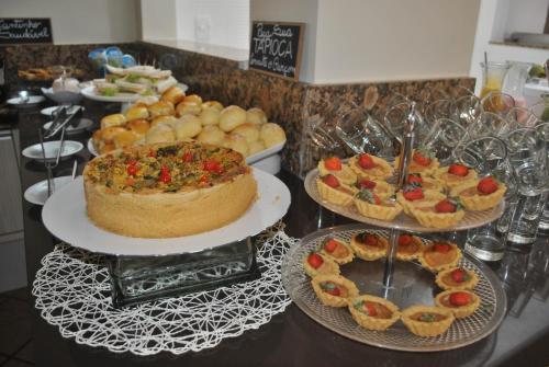 a buffet with pies and cakes on a table at Hotel Pousada do Sol in Aracaju