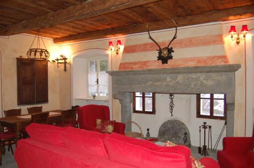 a living room with a red couch and a fireplace at Le Primule in Piedilago