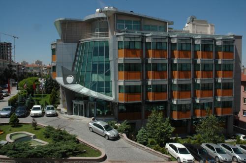 a building with cars parked in a parking lot at Hotel Midi in Ankara