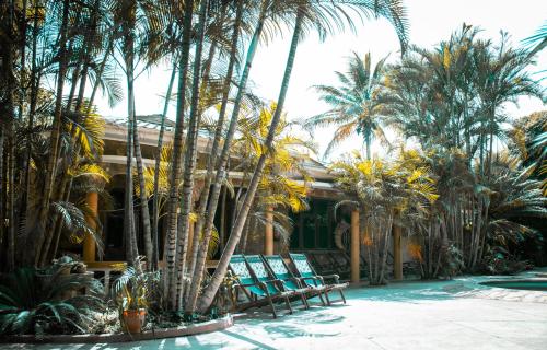 a group of chairs and palm trees in front of a house at The Paradise In Kilimanjaro in Moshi