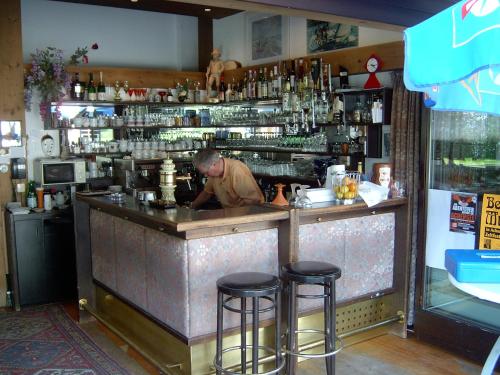 a man standing at a bar in a restaurant at Das Landhaus am See in Achenkirch