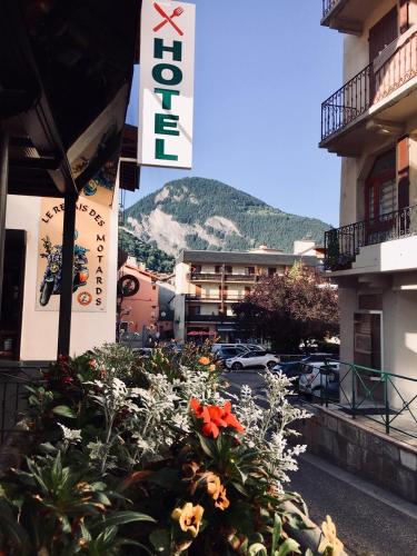 a sign for a hotel with flowers in front of a building at Hôtel Restaurant Angival - Chambres et Appartement in Bourg-Saint-Maurice