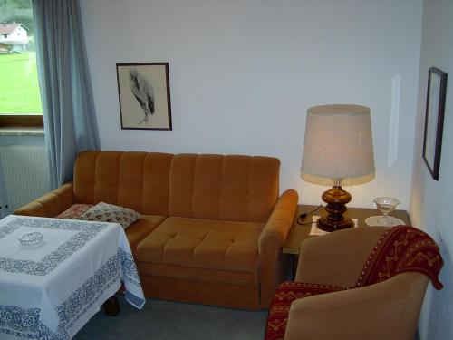 a living room with a couch and a table at Das Landhaus am See in Achenkirch