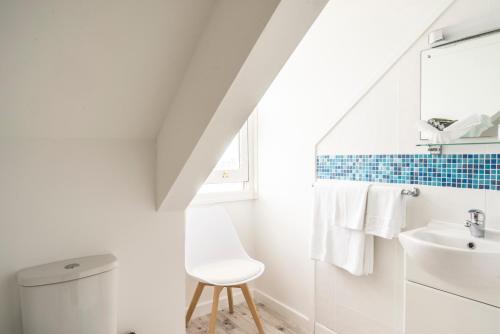 a white bathroom with a sink and a toilet at The Bay Hotel in Coverack
