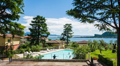 a swimming pool with a view of the water at Villenpark Sanghen in Manerba del Garda