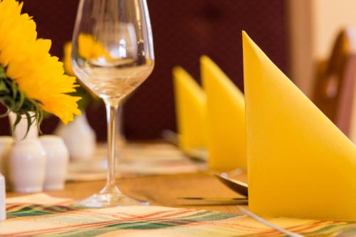 a table with yellow napkins and a glass of wine at Hotel Selsky Dvur - Bohemian Village Courtyard in Prague