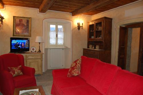 a living room with a red couch and a tv at Le Primule in Piedilago