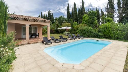 a swimming pool with chairs and a house at Vacancéole – Le Domaine de Camiole in Callian