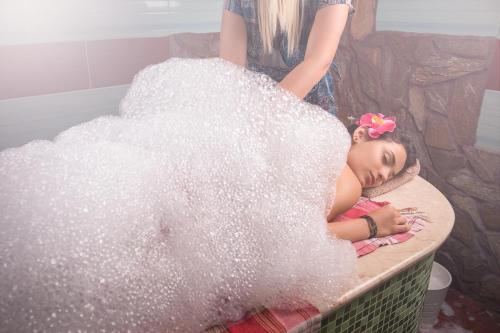 a young girl laying in a tub covered in glitter at Park & Spa Hotel Markovo in Plovdiv