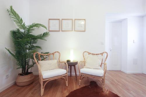 a living room with two chairs and a plant at Lavradores Boutique Guesthouse in Évora