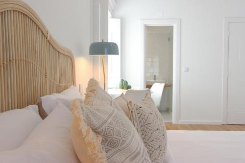 a bedroom with a bed with white pillows at Lavradores Boutique Guesthouse in Évora