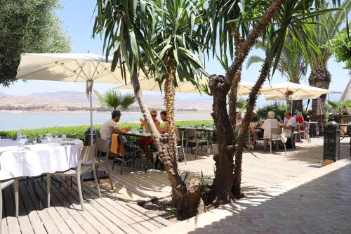 a group of people sitting at tables under umbrellas at Le Petit Hôtel du Flouka in Lalla Takerkoust