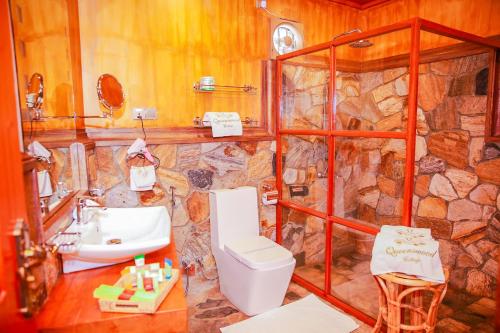 La salle de bains en pierre est pourvue d'un lavabo et de toilettes. dans l'établissement Queenswood Cottage, à Nuwara Eliya
