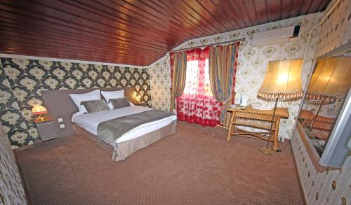 een slaapkamer met een bed, een tafel en een raam bij Pensiunea Lokanta in Daia