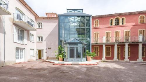 a glass building in the middle of a courtyard at Vacancéole – Le Domaine de Camiole in Callian