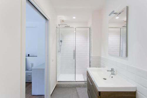 een witte badkamer met een douche en een wastafel bij Central Mezzanine in Palermo