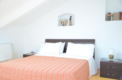 a bedroom with a bed with a orange and white striped blanket at La Soffitta Sul Mare in Vietri sul Mare