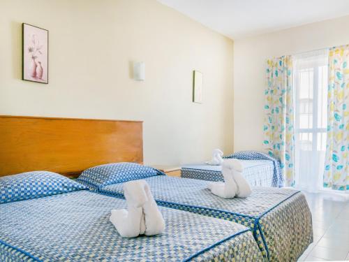 Dos camas con animales de peluche en un dormitorio en Qawra Point Holiday Complex en St Paul's Bay